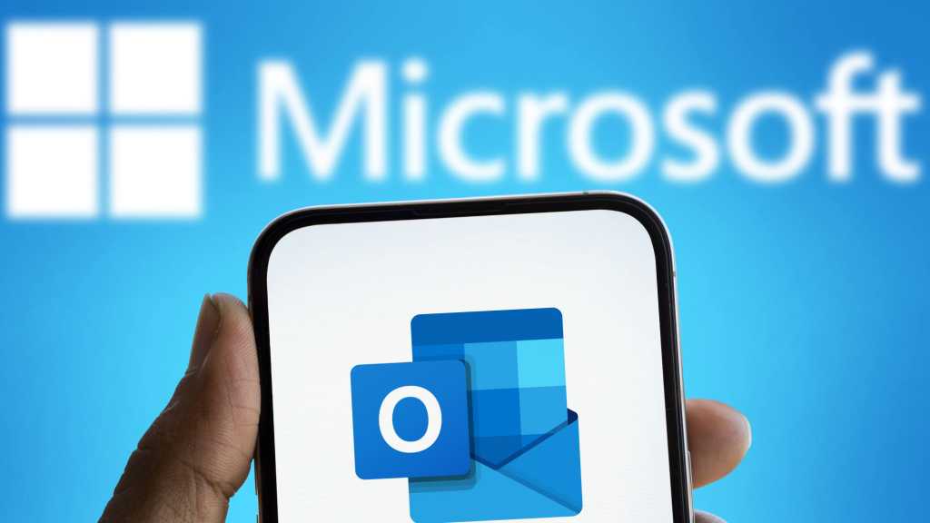 Microsoft Schriftzug im Hintergrund und Outlook Logo auf Smartphone im Vordergrund